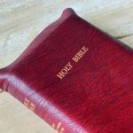 a close up of a bible on a wooden surface